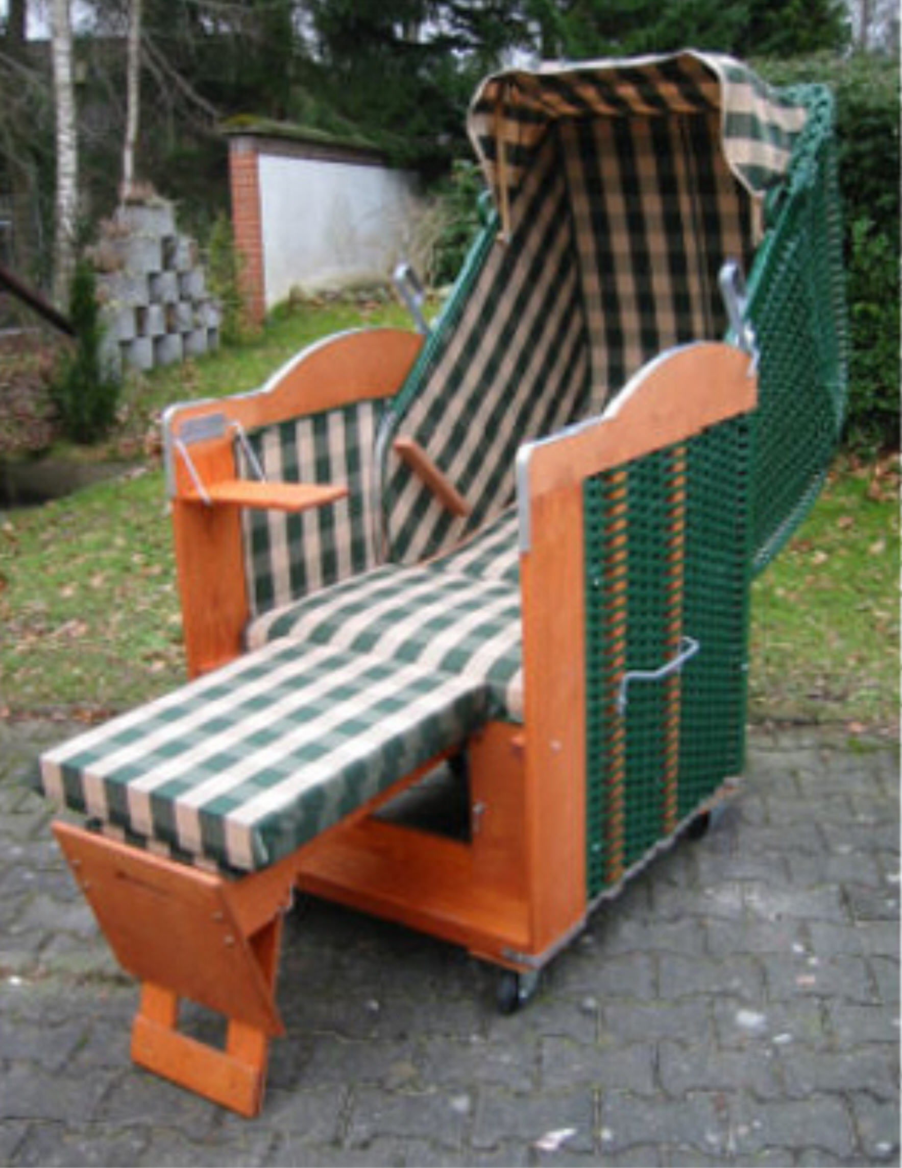 Der 1-Sitzer Strandkorb hat ein Geflecht aus PVC in der Farbe moosgrün mit einem karierten Stoffdesign in grün-beige.